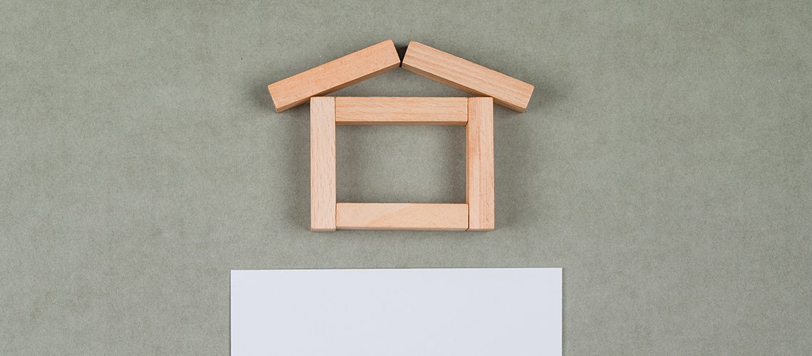 Real estate concept with wooden blocks, sticky note on grey background flat lay.
